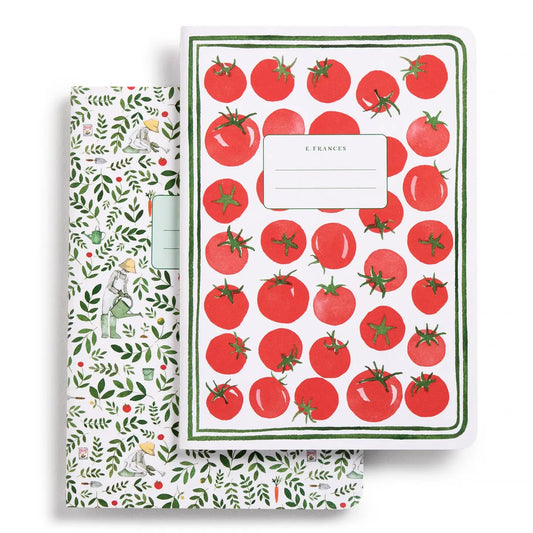 Notebook with tomato pattern and another with garden-themed design on a white background