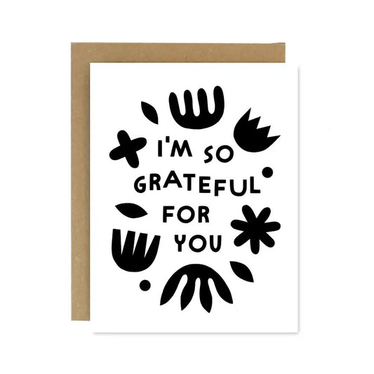 White greeting card with a black text that reads 'I'm so grateful for you' surrounded by abstract shapes