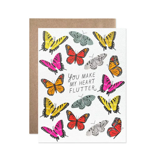 Greeting card with colorful butterflies and text 'You make my heart flutter' on a white background.