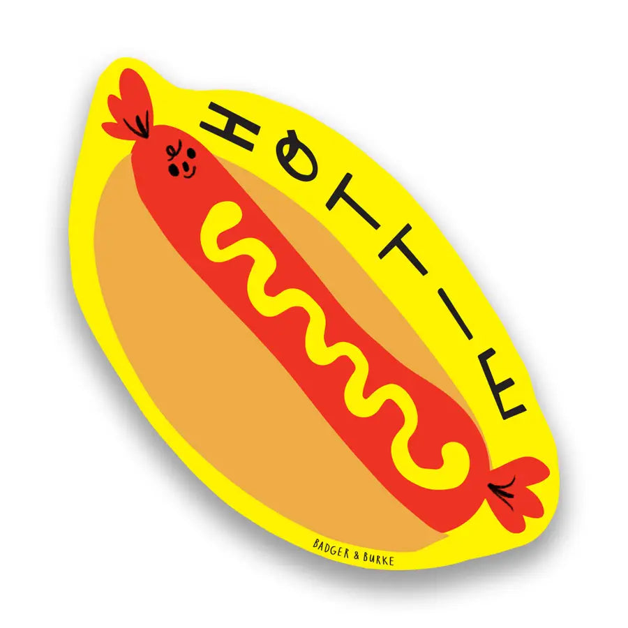 Hot dog shaped sticker. Yellow background with brown and red hotdog. Black text reads "hottie"