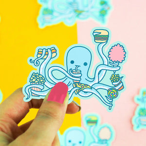 Die-cut sticker of a blue octopus holding fast food and candy in its arms 