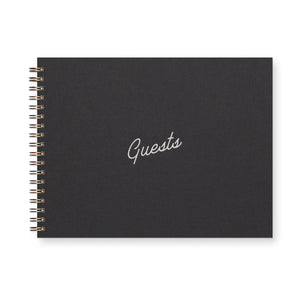 Spiral-bound black notebook with white text reading "guests" 