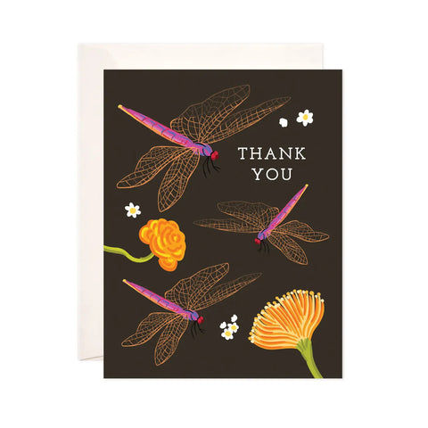White card with black background. Three pink and gold dragonfly and two yellow flower illustrations . White text reads "thank you" 