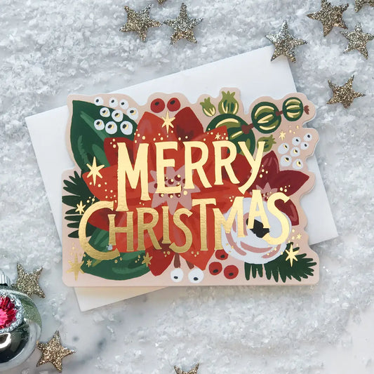 Greeting card die-cut in the shape of a poinsettia. Gold foil text "Merry Christmas"