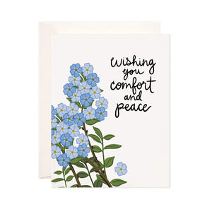 White card with illustration of blue flowers. Black text reads "wishing you comfort and peace"