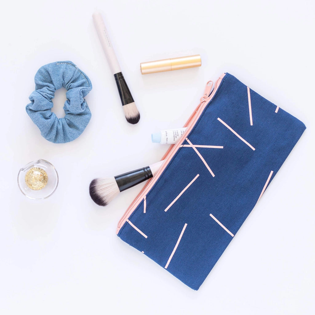 View of navy bag with cosmetic brushes coming out of it 