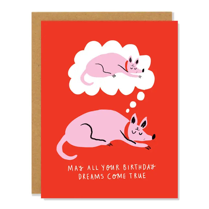 Red card with drawing of pink dog napping. Dog is dreaming of himself napping. White text reads "may all your birthday dreams come true." Inside of card is white.