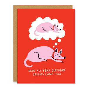 Red card with drawing of pink dog napping. Dog is dreaming of himself napping. White text reads "may all your birthday dreams come true." Inside of card is white.