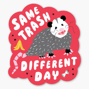 Red sticker with an illustration of a possum and banana peel. White text reads "same trash different day"