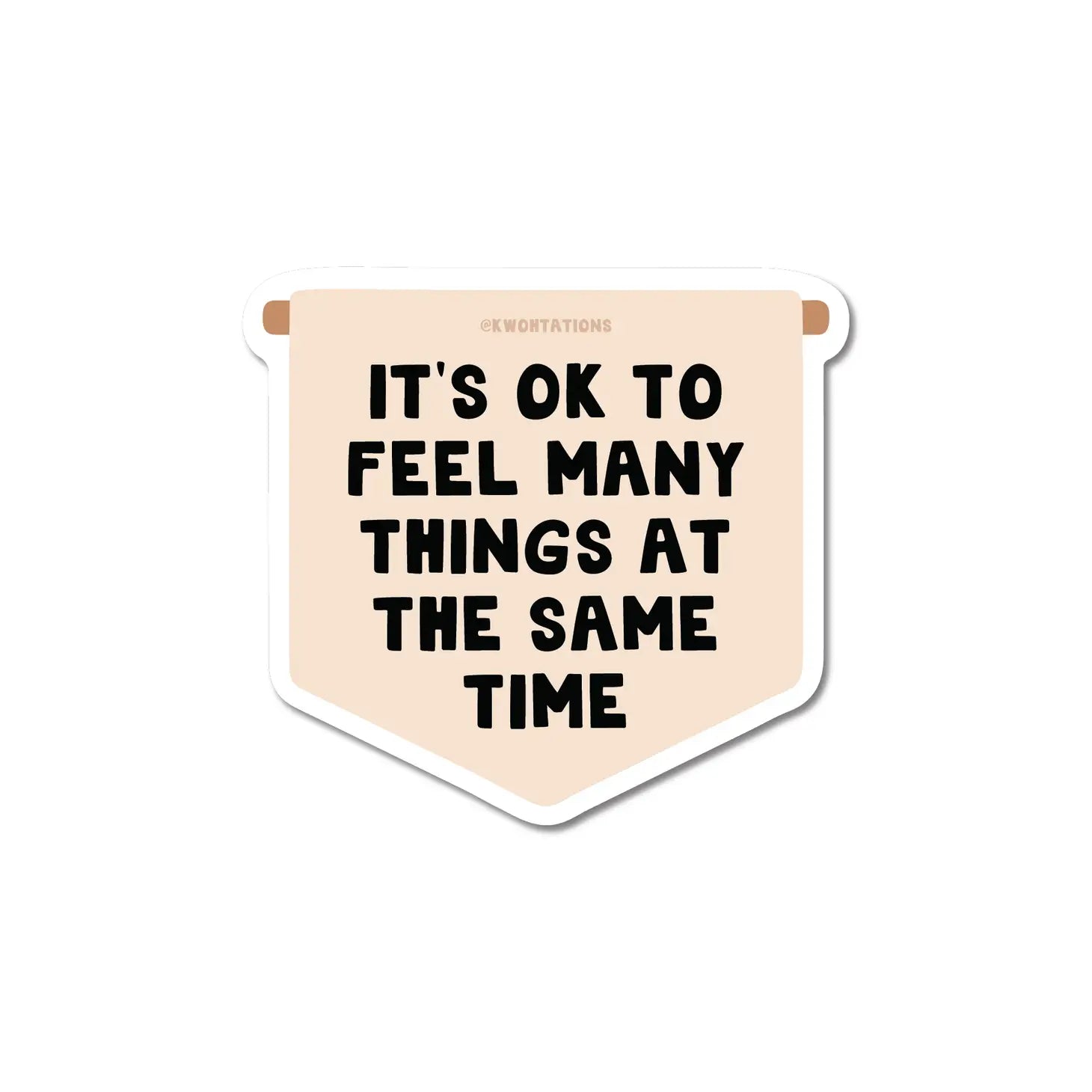 Vertical flag-shaped sticker with tan background. Black text reads "It's ok to feel many things at the same time"