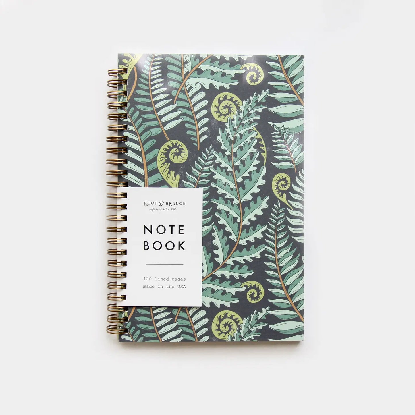 Front cover of a spiral notebook. Navy and green forest fern design on the cover 