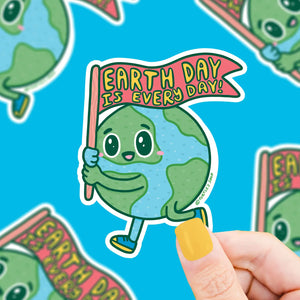 Die cut-sticker with a blue and green earth holding a red sign. Yellow text on the sign reads "earth day is every day" 
