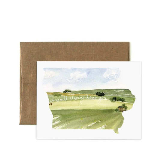 White greeting card with watercolor painting of Iowa fields and sky. White text “iowa’ll always love you” 