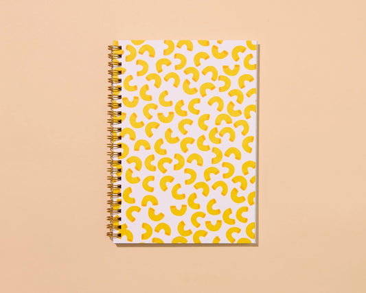 Front cover of a spiral notebook featuring yellow macaroni pattern 