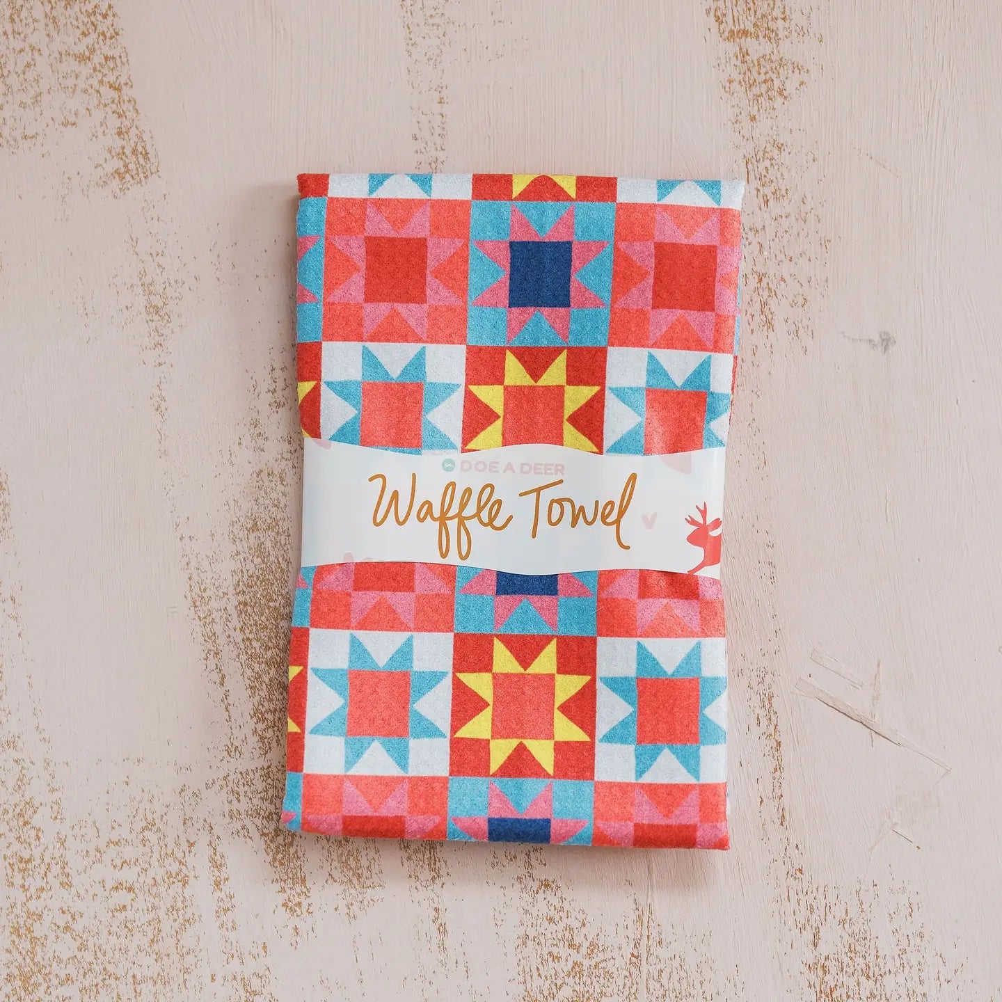 Waffle towel with colorful quilt pattern on a textured surface