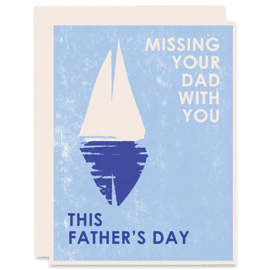 White card with full color blue background. White and navy sailboat print. White text reads "missing your dad with you" and navy text reads "this father's day." 