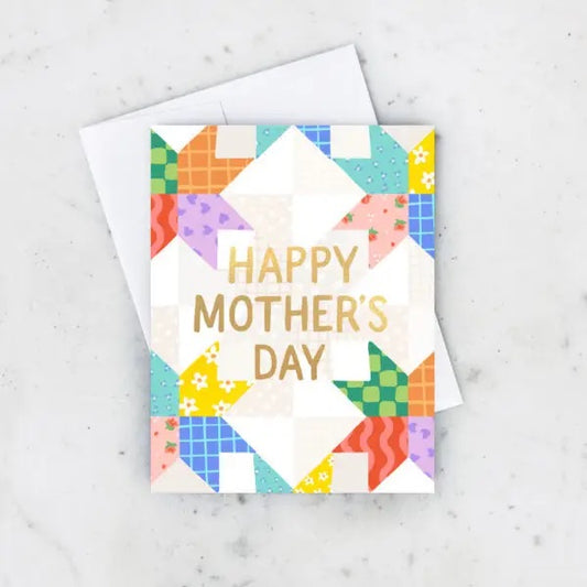 White greeting card with multicolor quilt pattern. Gold text “happy Mother’s Day” 