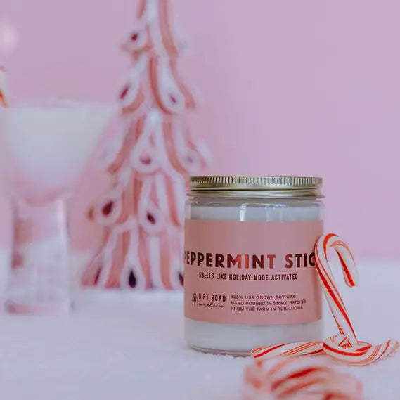 Candle jar with a pink label 'Peppermint Stick' with candy canes on a pink background