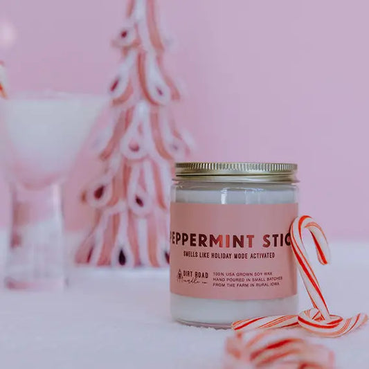 Candle jar with a pink label 'Peppermint Stick' with candy canes on a pink background