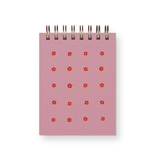 Pink top spiral mini notebook with red floral patterns on a white background