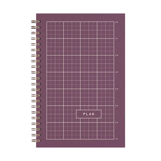 Purple planner notebook with grid pattern and 'PLAN' text on a white background