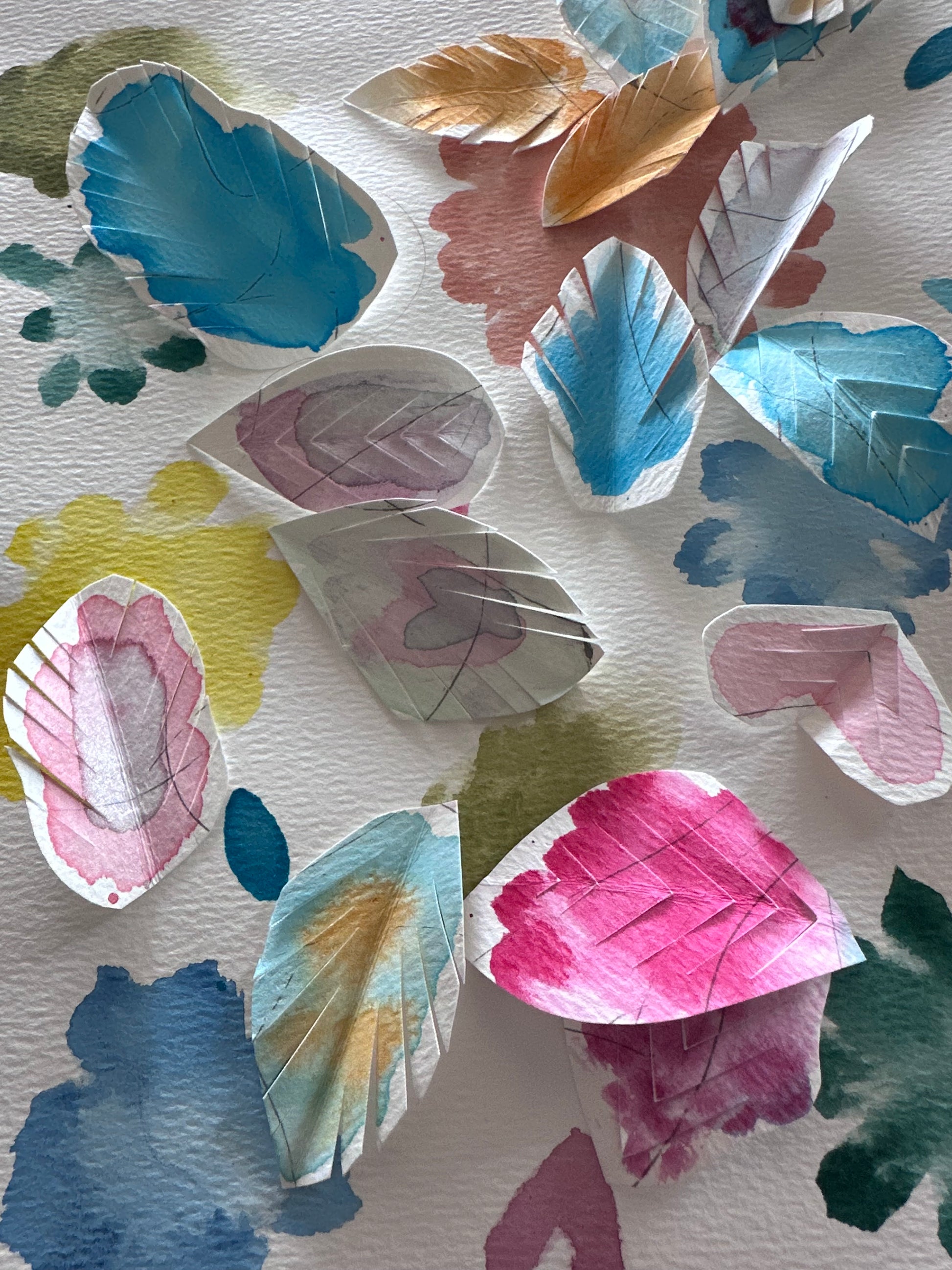 Colorful leaf-shaped paper cutouts on a textured white background