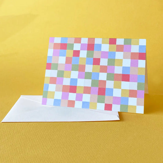 Colorful checkered card with a white envelope on a yellow background