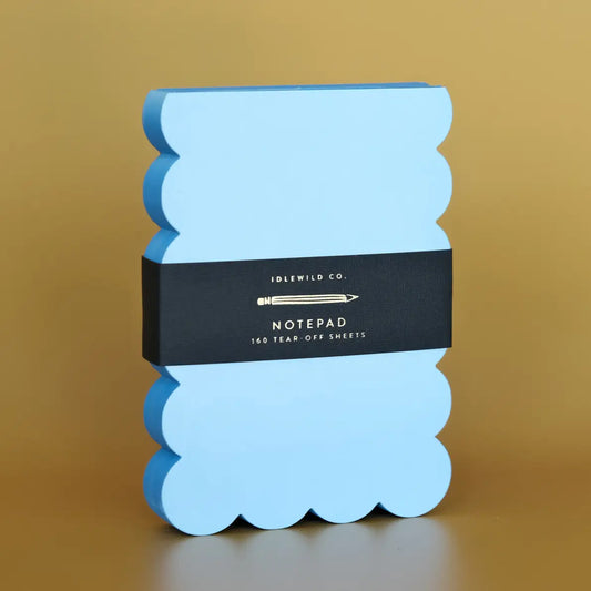 Blue scalloped notepad with a black band featuring 'Idlewild Co.' branding