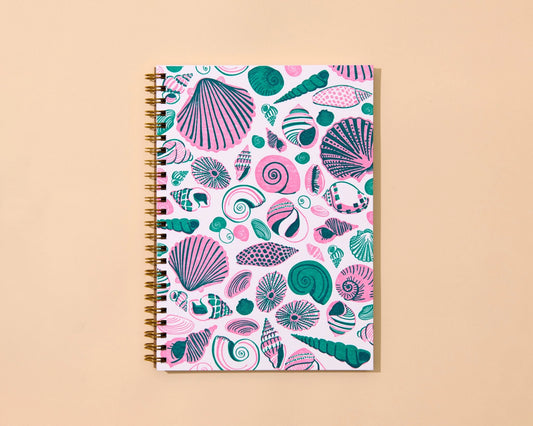 Notebook with seashell pattern on a beige background