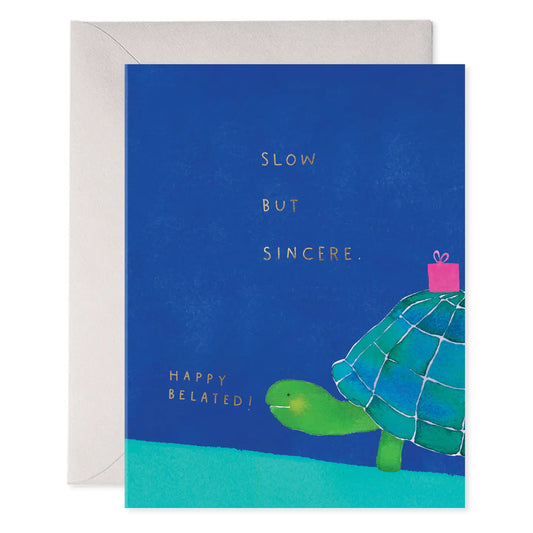 Greeting card with turtle illustration and gold foil text on a blue background