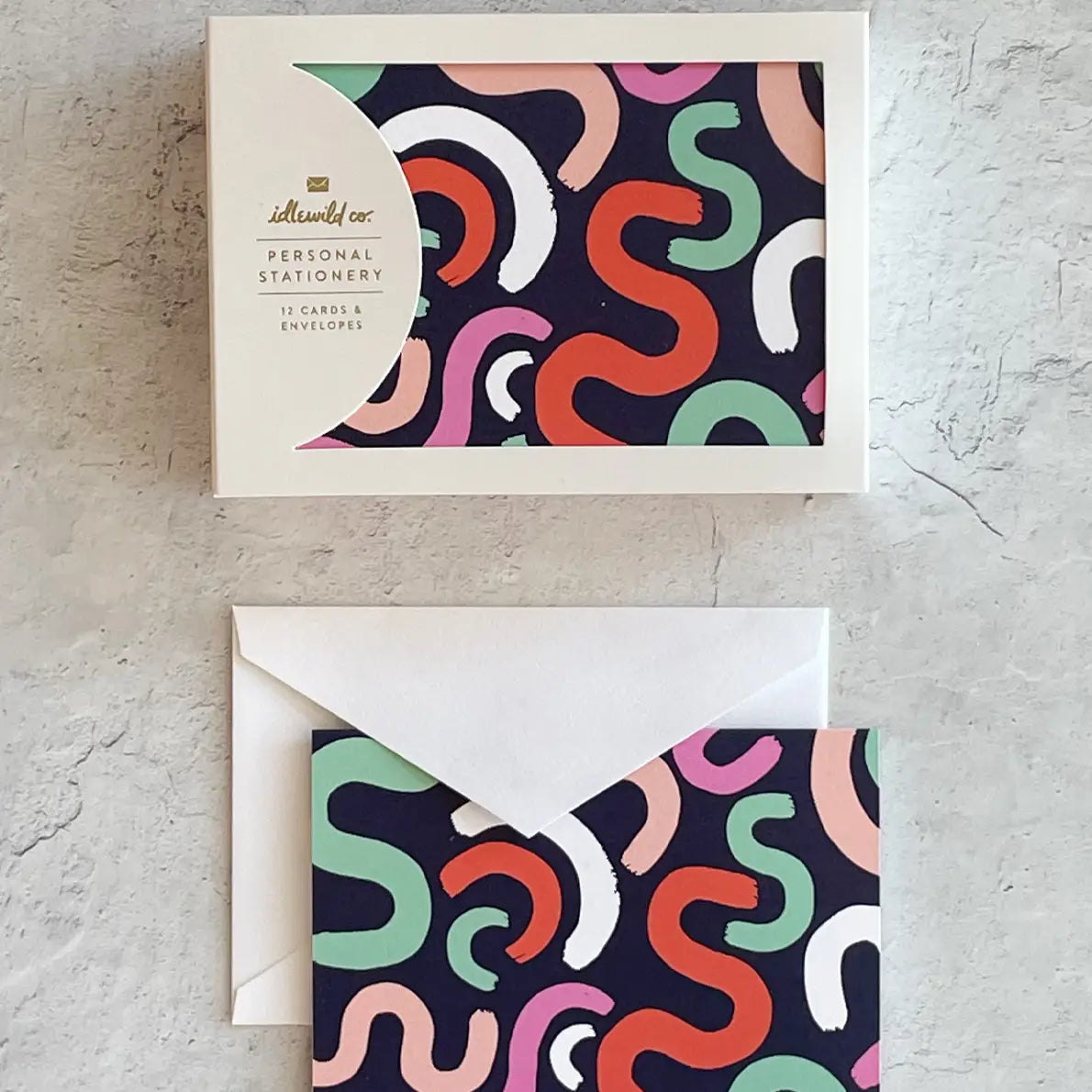 View of cards in a white box and next to a white envelope 