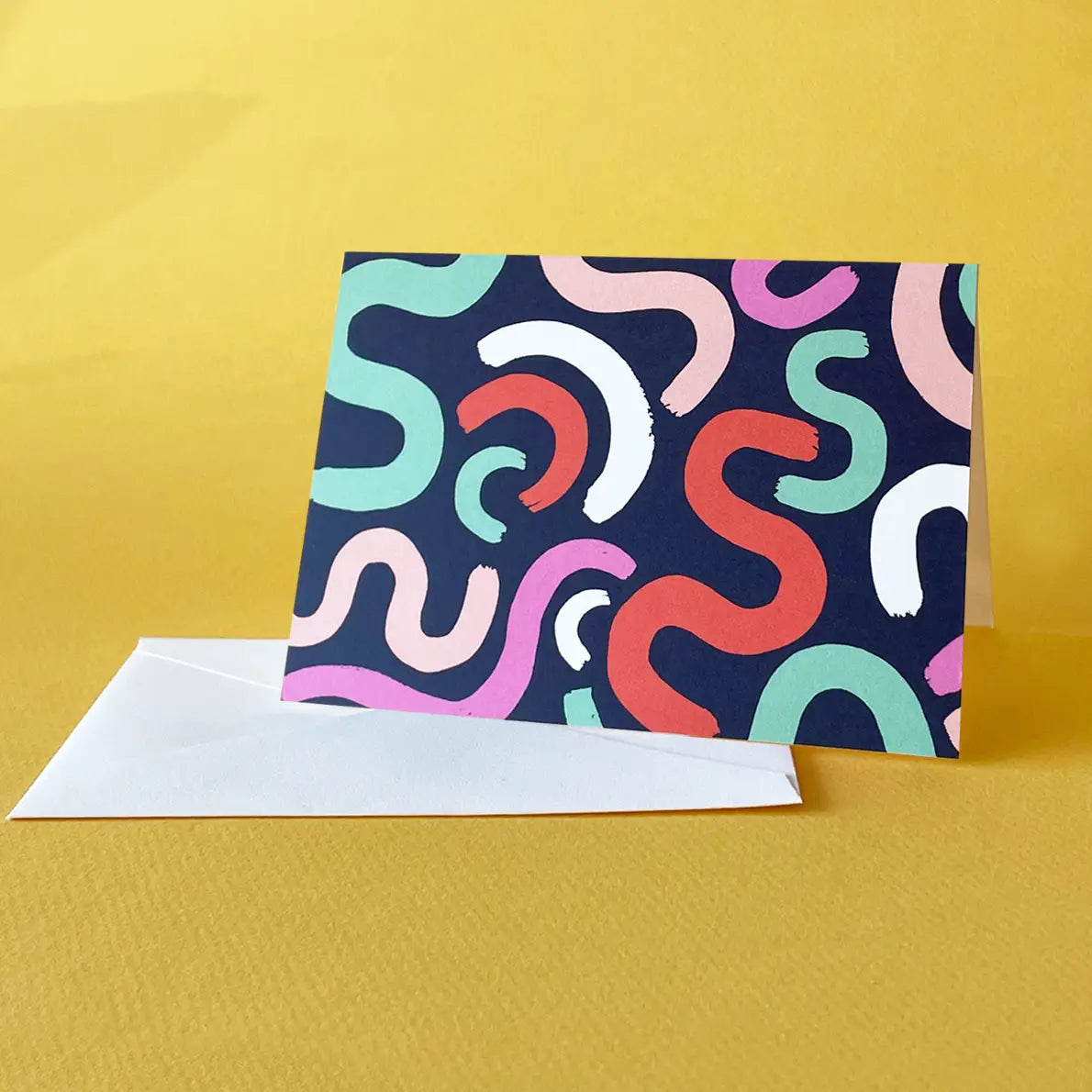 White card with navy background and mint green, white, red, and pink squiggles 