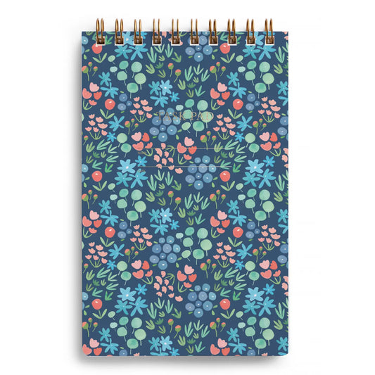 Top spiral notebook with floral pattern on a blue background