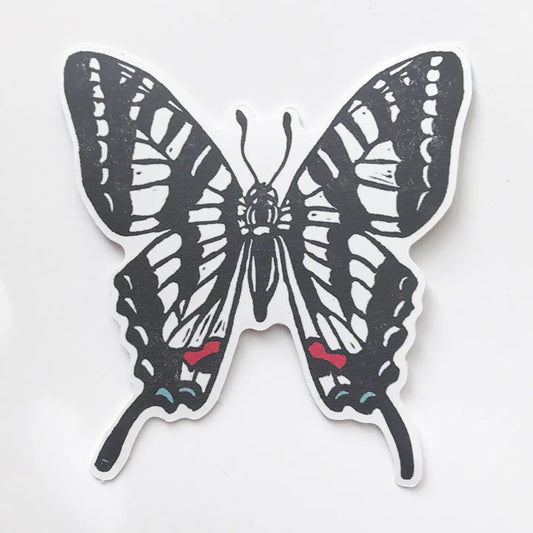 Black and white butterfly sticker with red accents on a light gray background