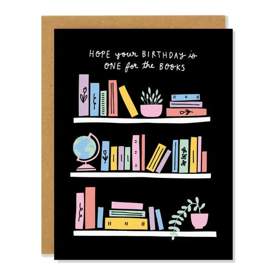Black card with drawing of shelves of books. White text reads "hope your birthday is one for the books." Inside of card is white.