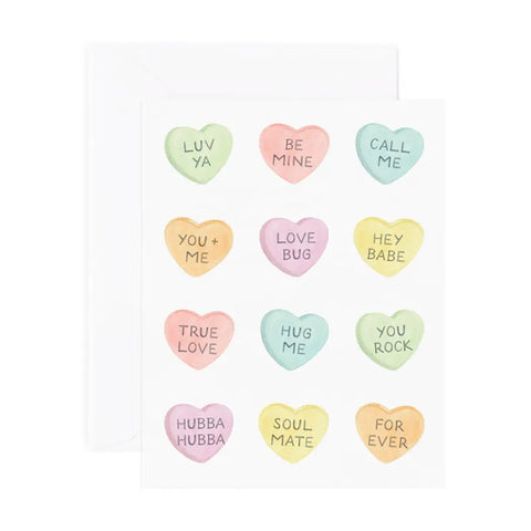 White card. 12 candy heart drawings in a variety of colors: green, red, blue, orange, yellow, and pink. Candy hearts feature black text of loving statements. 