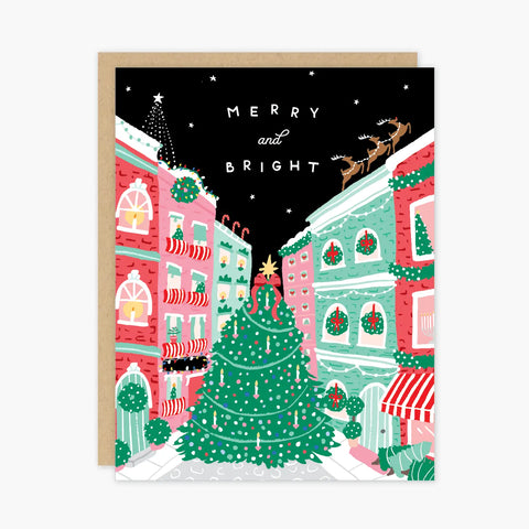 Black card with holiday town square Christmas tree. White text reads "merry and bright." Card is white inside