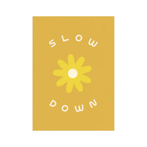Dark yellow background. White text reads "slow down." Lighter yellow flower drawing in middle. 