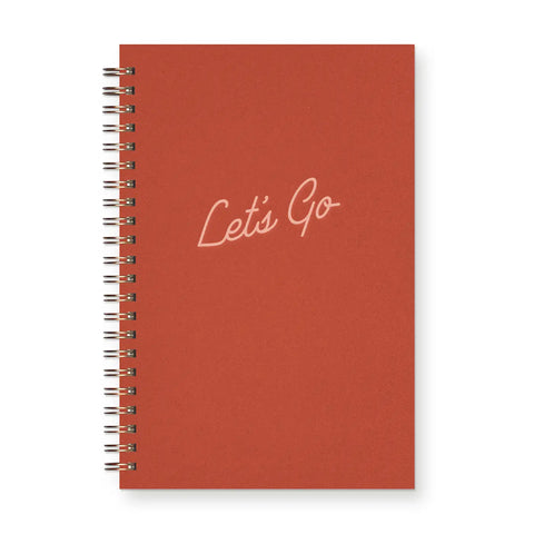 Red spiral-bound notebook with pink text reading "let's go"