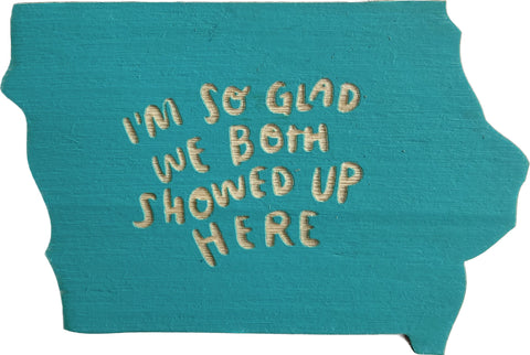 Iowa shaped magnet in aqua. Laser cut lettering reads "I'm so glad we both showed up here"