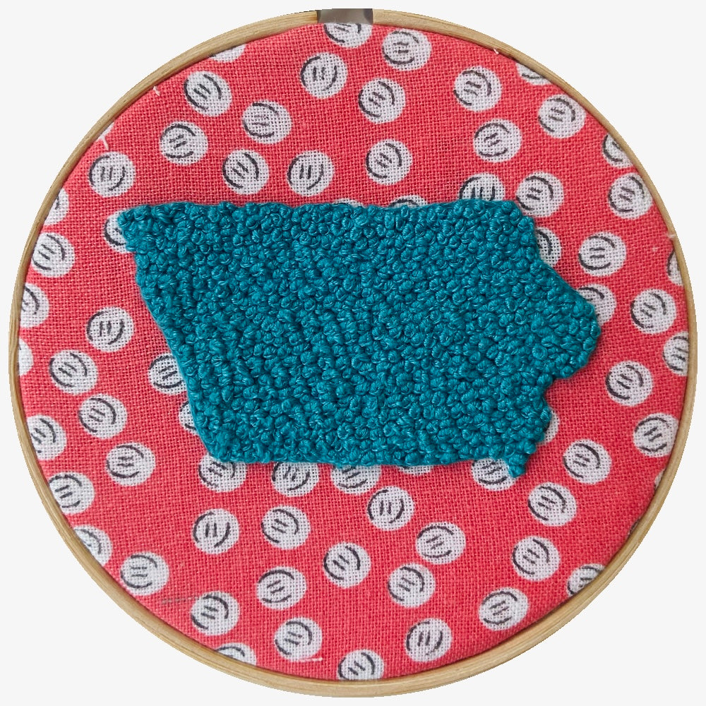 blue Iowa embroidered on pink and white fabric