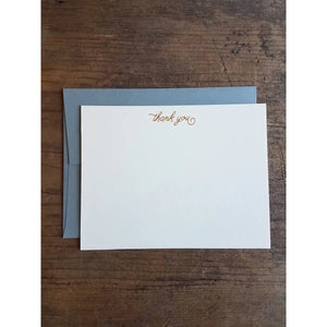 White notecard with gold text reading "thank you" in middle top