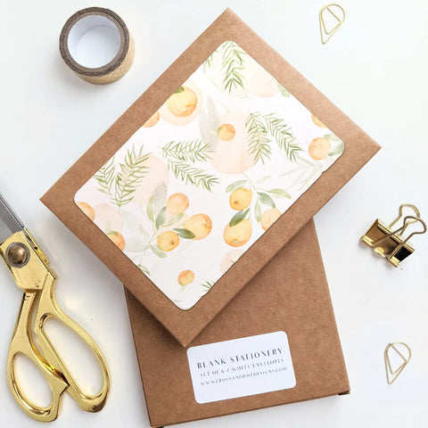 Brown kraft box of cards. White cards feature yellow clementines