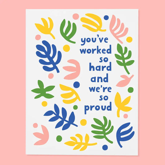 White greeting card. Blue text “you’ve worked so hard and we’re so proud” 