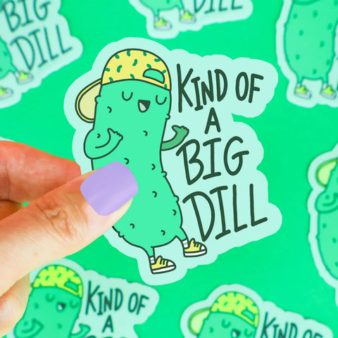 Green pickle wearing a yellow baseball hat. Dark green text reads "kind of a big dill"