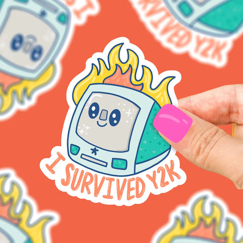 Turqouise I-mac shaped sticker with a fire behind it. Orange text reads "I survived Y2K"