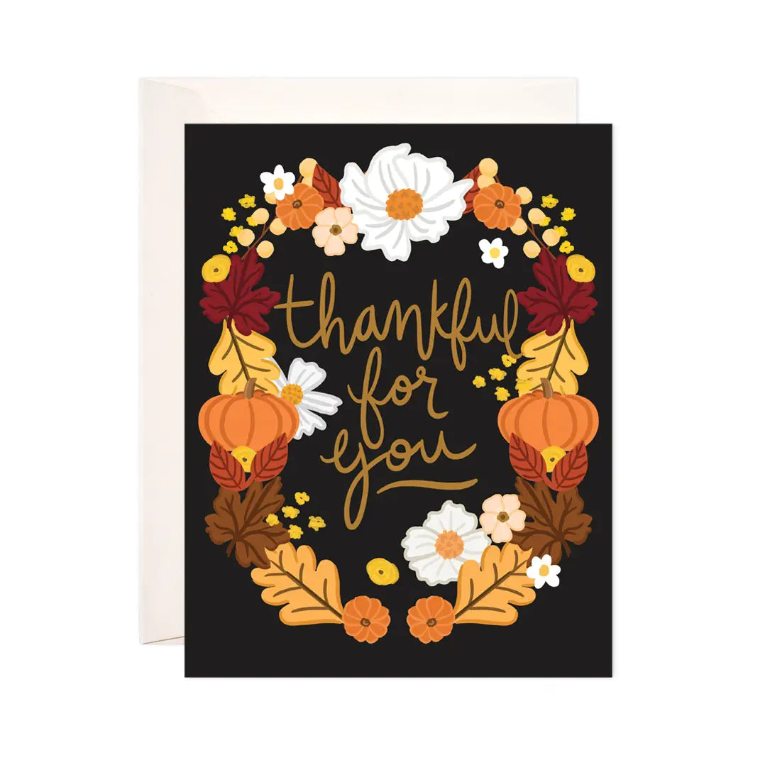 White card with black background. Autumn garland of flowers, leaves, and pumpkins surround brown text "thankful for you" 