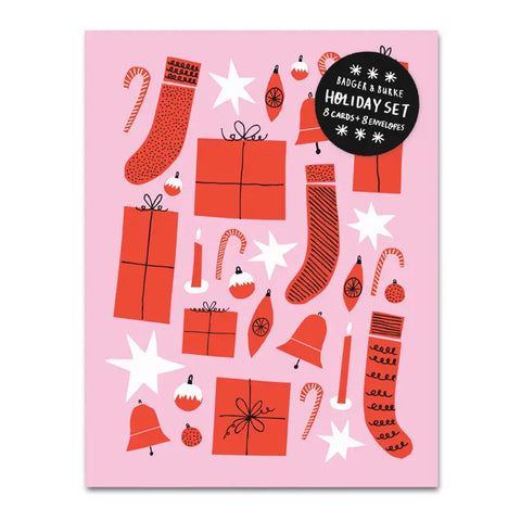 Pink card with drawings of red stockings, presents, candy, candles, and bells and white stars. Inside of card is white.