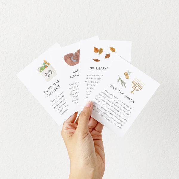 Four white cards with seasonal self care prompts. 