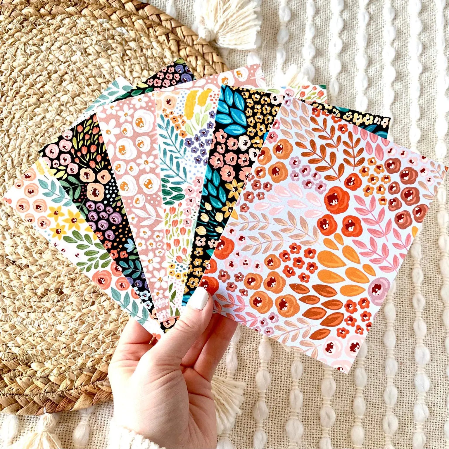 Hand holding six different floral patterned cards 